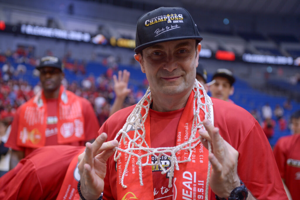 Basketball coach wearing cut net as necklace after championship win