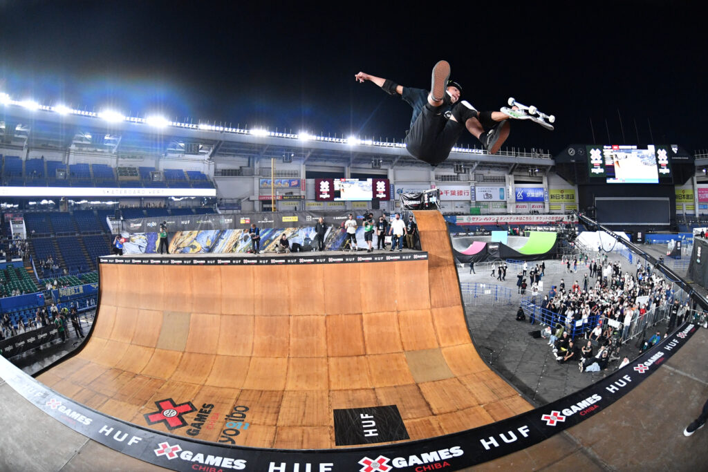 Skateboarder launches high above vert ramp during X Games