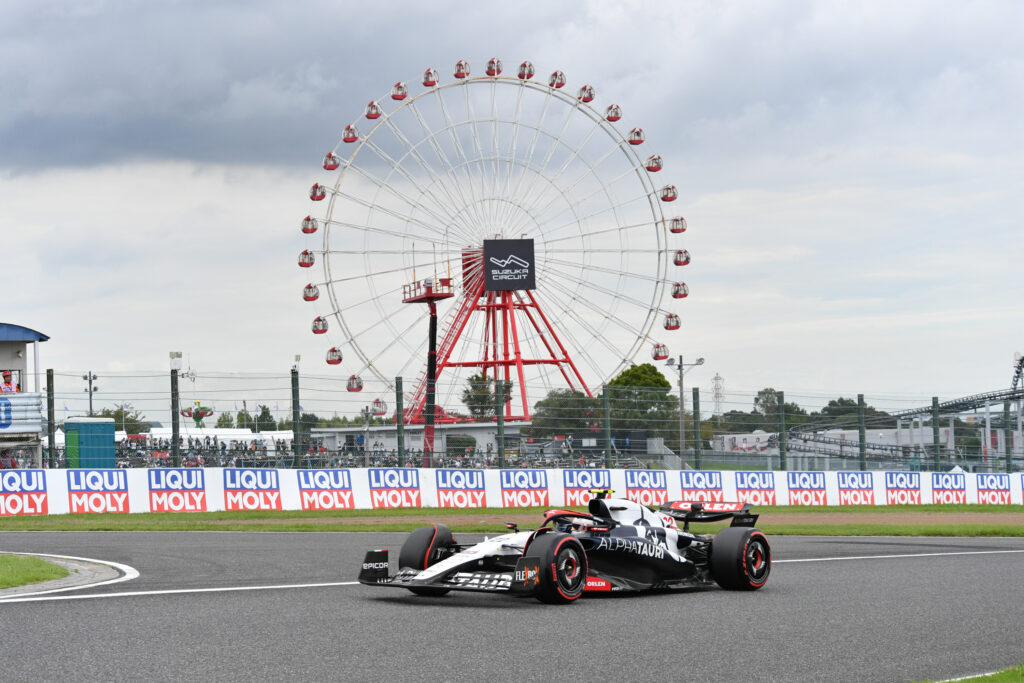 AlphaTauri Formula 1 car racing at Suzuka with ferris wheel background